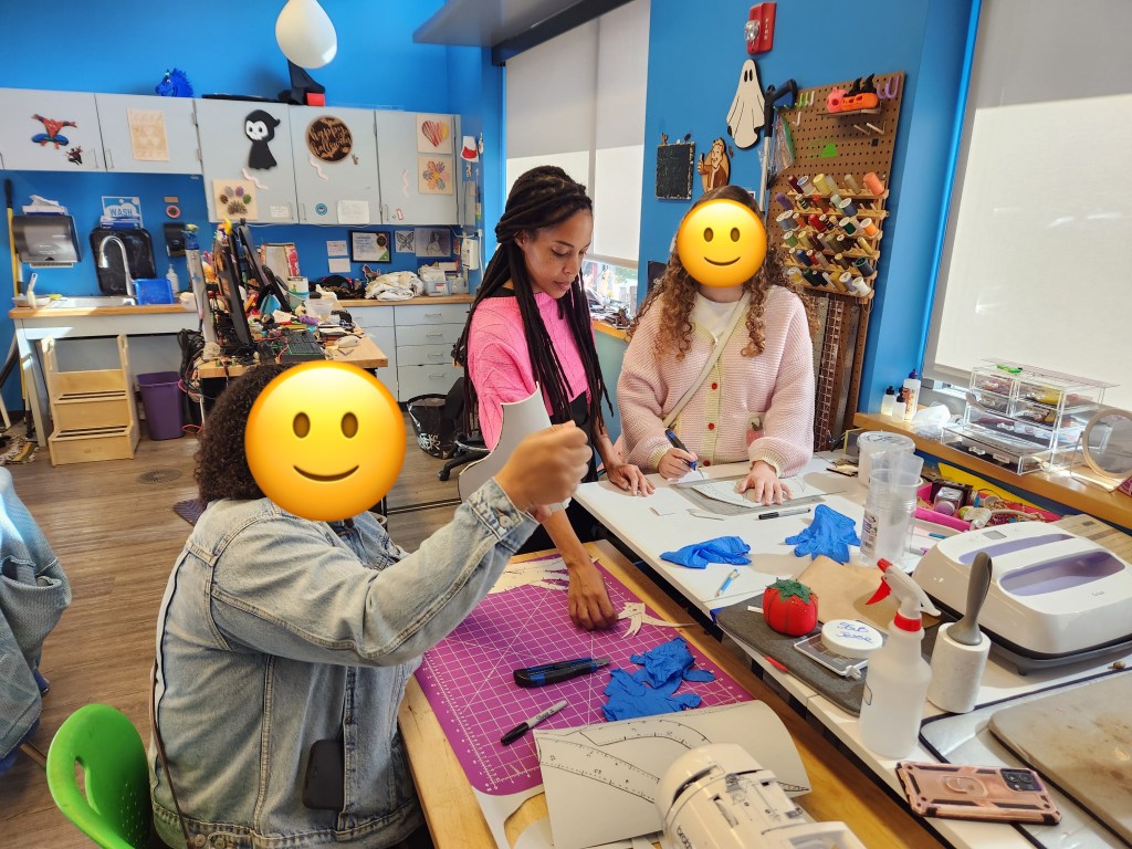 Brittany teaching two anonymous library patrons how to use EVA foam in the idealab makerspace 